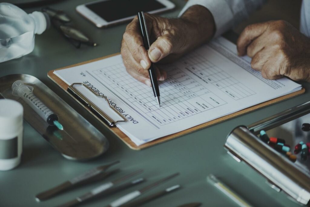 Medical administrator hands filling a daily report schedule form